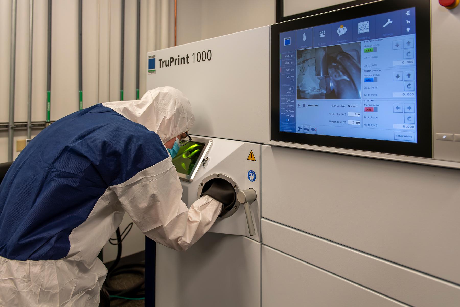 Person in a lab suit using the Trumpf TruPrint 1000